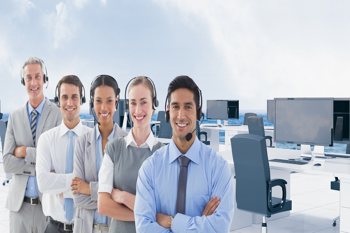 Call center executive wearing headphones and standing with arms crossed in office